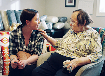 Mary Galloway sits with Sarah Modeste to learn the history of the Cowichan sweater. 