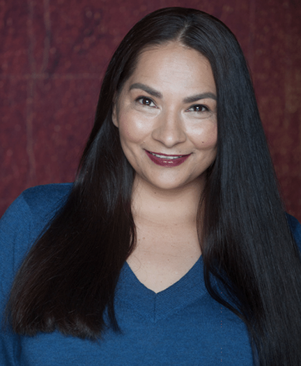 Photo of a smiling woman with long straight black hair hanging over here shoulders.