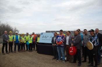 People gather around a new sign marking the location of the new solar farm in Edmonoton.