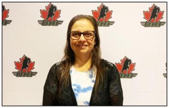 Gayle Payette stands in front of a screen printed with the logo of the Ontario Hockey Federation  