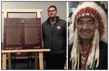 Gabriel Michael stands with plaque. With photo of Wilton Littlechild in a headdress.