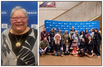 Dr. Lorna Wánosts’a7 Williams seen with a group in front of a banner.