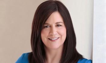 A woman with shoulder-length dark hair smiles toward the camera.