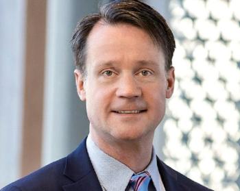 A head and shoulders photo of a man in a suit and tie.