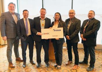 A line of people stand in holding a poster board that has the logos of CIB, WMA and Nova Scotia Power on it.