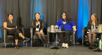 Sitting on chairs on a stage are four women.