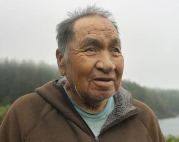 A man stands on a misty coastal outlook over the bay at Yuquot, Friendly Cove, in Nootka Sound, B.C.