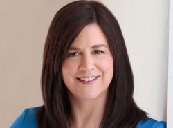 A woman with shoulder-length dark hair smiles toward the camera.