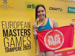 Gold medal for swimmer who holds up her hardware and the Haida Gwaii flag.