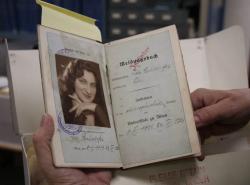 A small book is open to a black and white photo of a young woman.